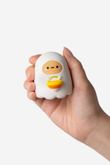 Hand holding a Ghost Tayto Potato figure on a white background.